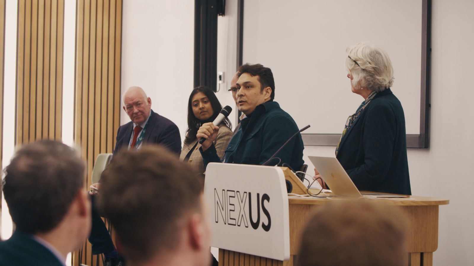 Nima Eskandari speaking on a panel at a NEXUS event