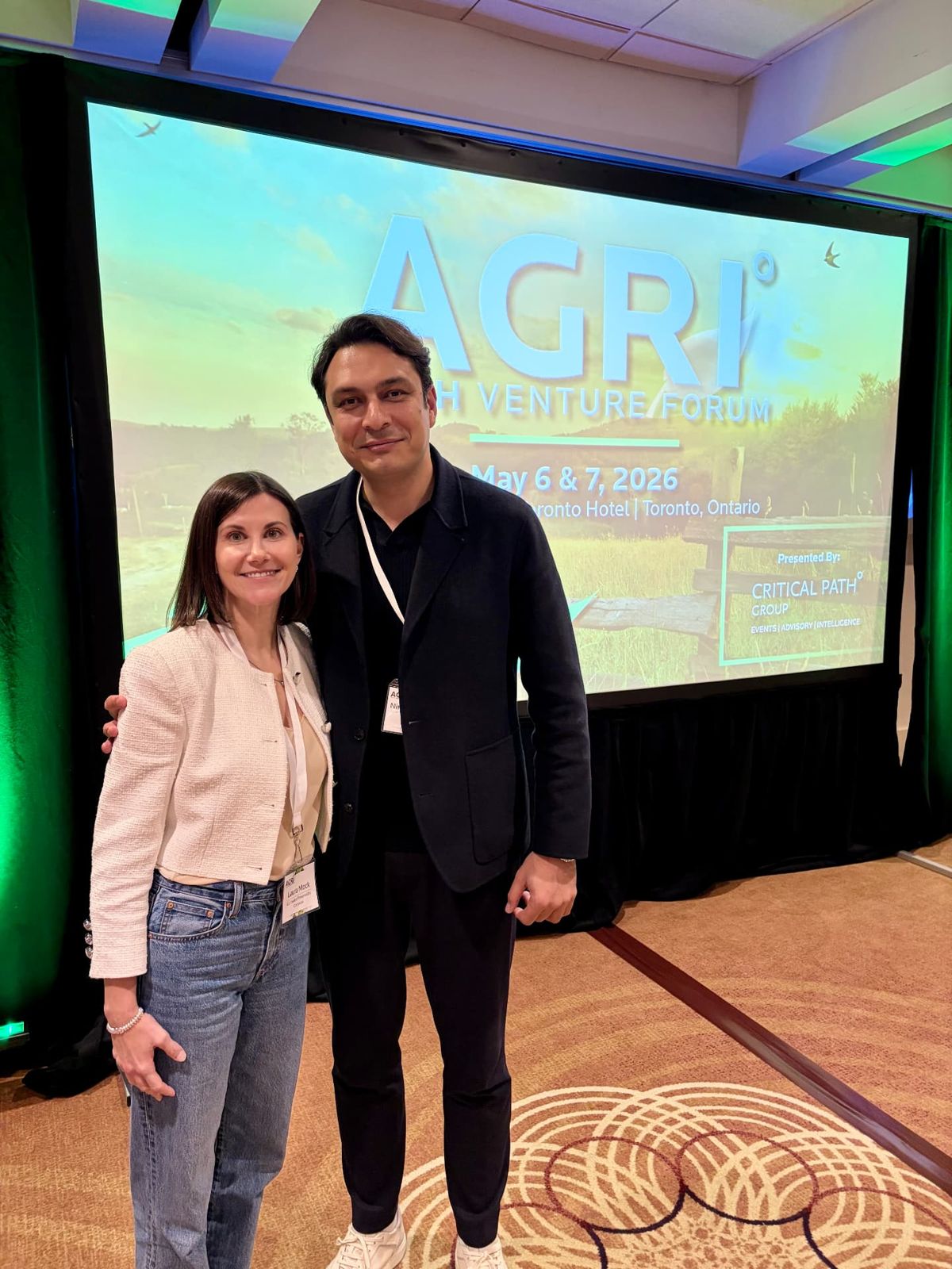 Two people in front of the AGRI Tech Venture Forum screen in Toronto, May 2026