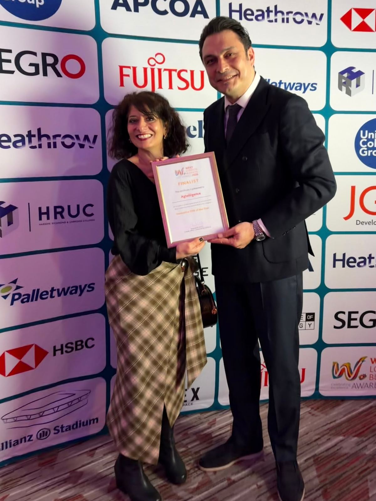 A woman and a man holding a finalist certificate at an awards event